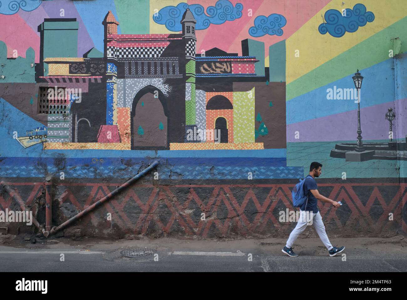 A man passes a colorful wall painting in Byculla area of Mumbai, India