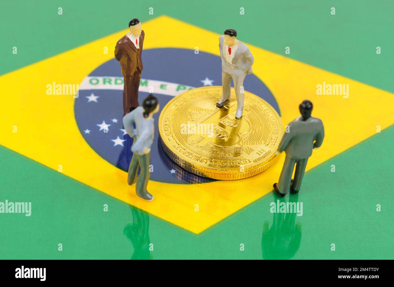 Cryptocurrency and business concept. On the surface with the image of the  flag of Brazil are bitcoins and miniature figurines of people Stock Photo -  Alamy