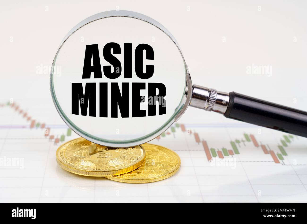 Business and technology concept. On the chart with quotes are bitcoins and there is a magnifying glass with the inscription - Asic miner Stock Photo