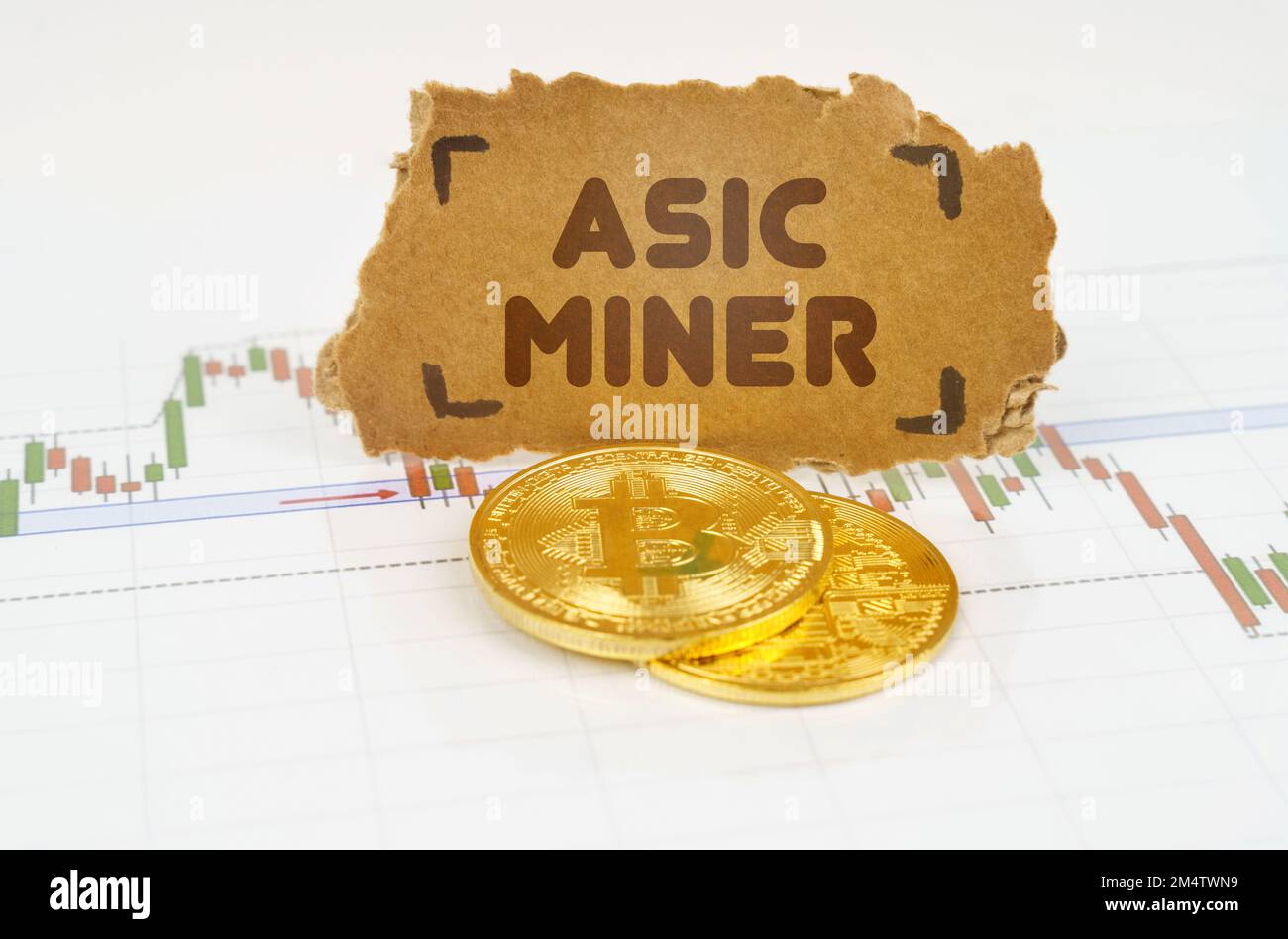 Business and technology concept. On the chart with quotes, there are bitcoins and there is a sign with the inscription - Asic miner Stock Photo