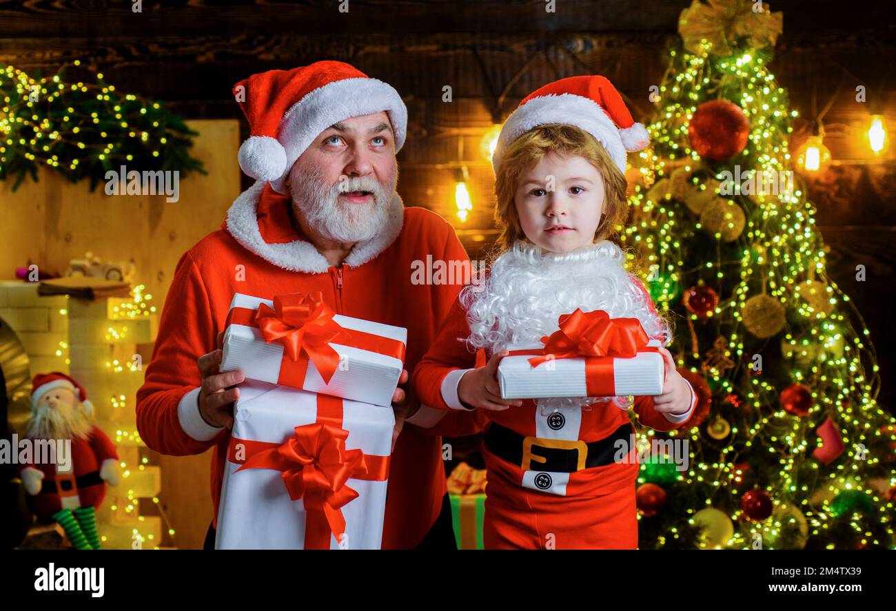 Santa Claus and little child with Christmas present at home. Family holidays. Happy New year. Stock Photo