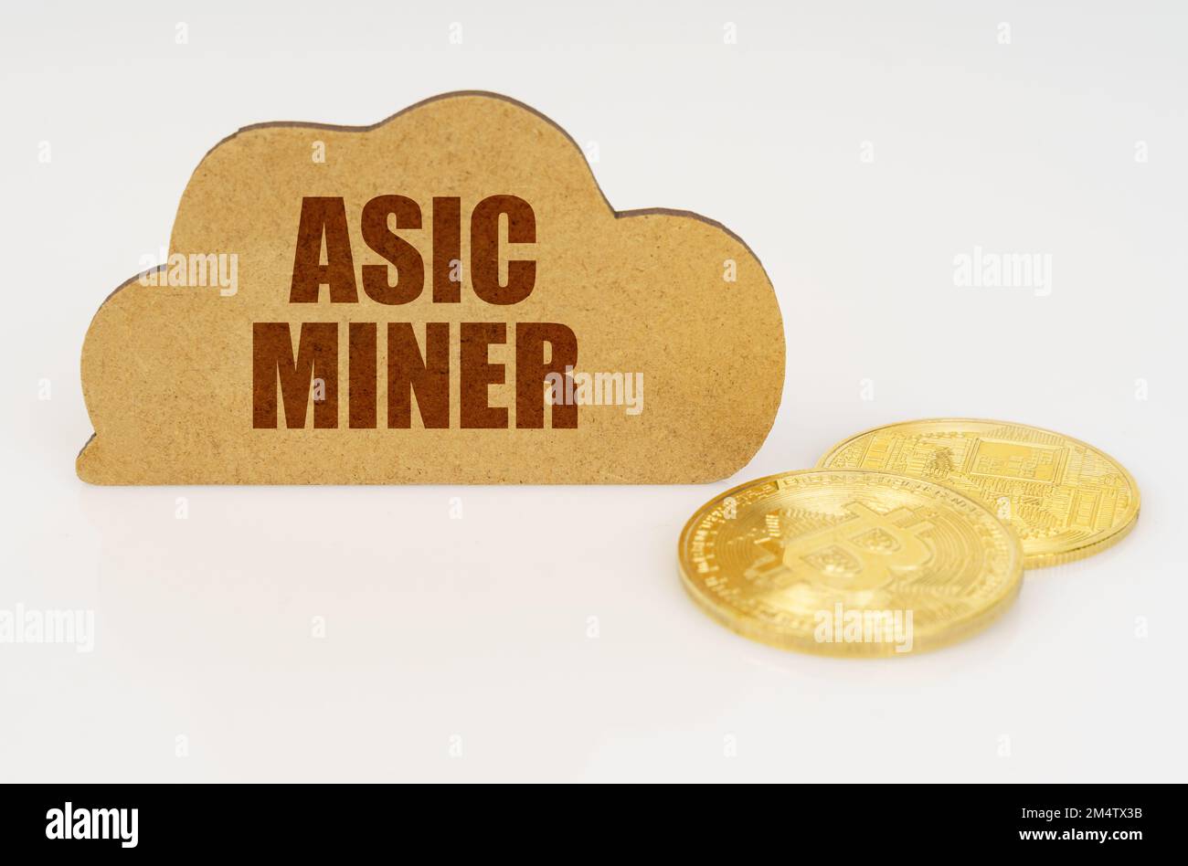 Business and technology concept. Bitcoins lie on a white surface and there is a sign - a cloud with the inscription - Asic miner Stock Photo
