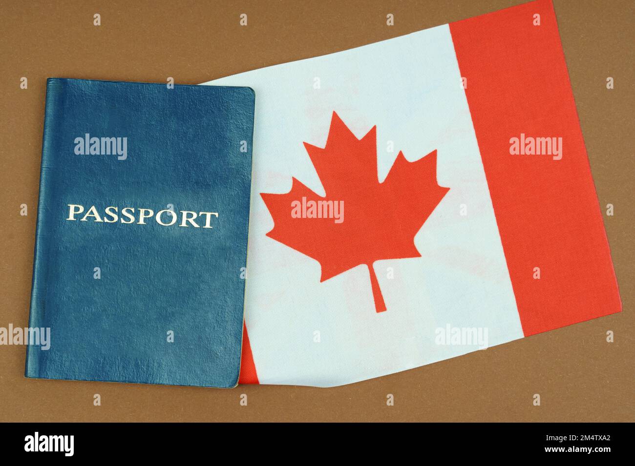 Migration concept. On a brown surface lies a passport inside which is the flag of Canada. Stock Photo