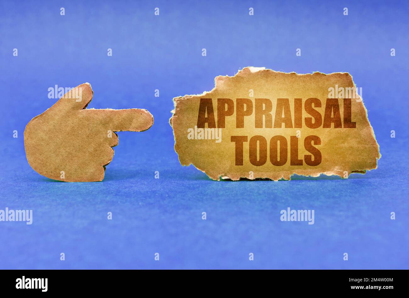 Business concept. On a blue surface, a cardboard hand points to a sign ...