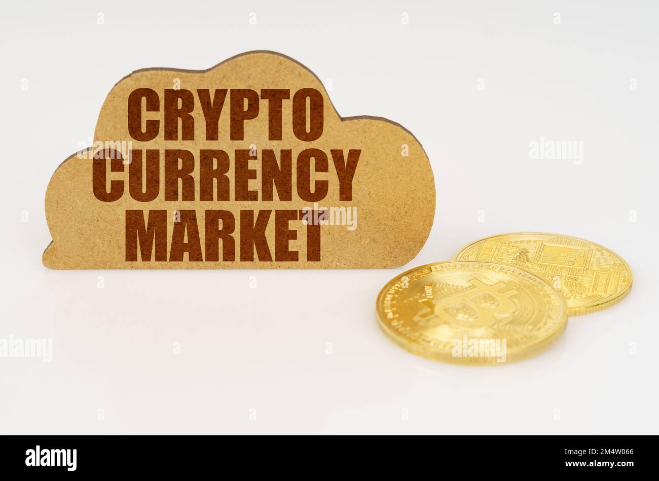 Business and technology concept. Bitcoins lie on a white surface and there is a sign - a cloud with the inscription - Crypto currency market Stock Photo