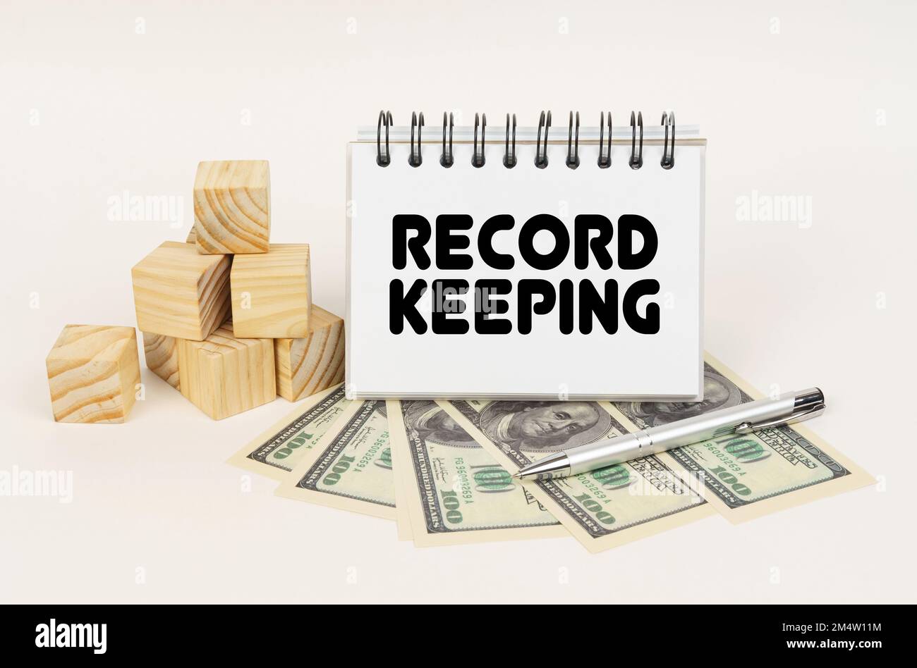 Business concept. On a white surface, cubes, dollars, a pen and a notepad with the inscription - Record keeping Stock Photo