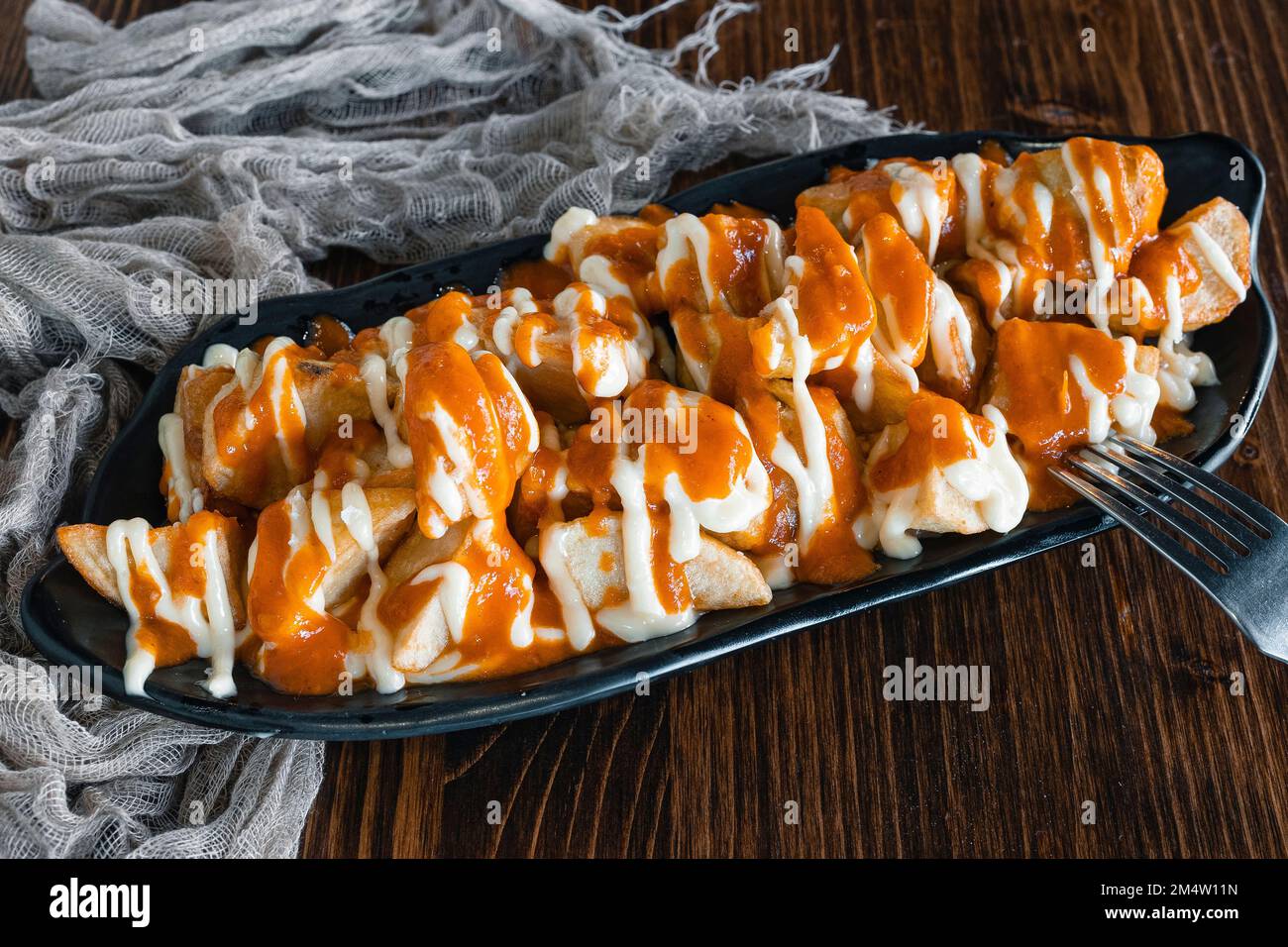 Patatas Bravas, traditional Spanish tapas, baked potatoes with spicy