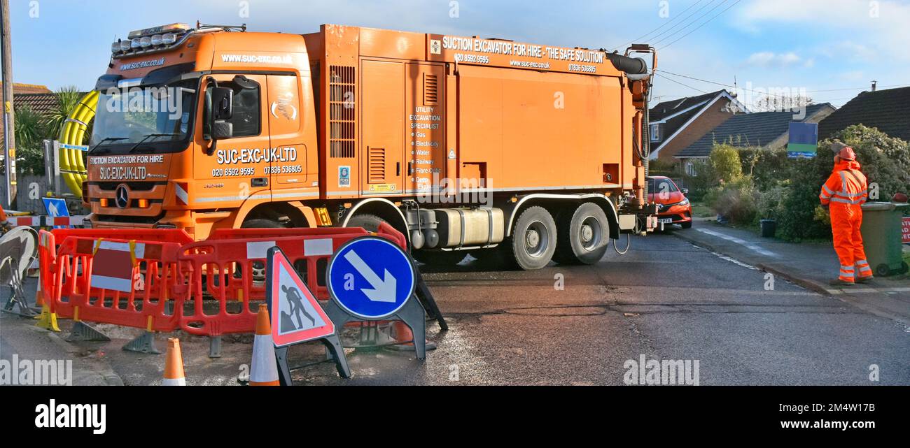 Empty cab lorry truck slowly reversing Suction Excavation machine hgv driver standing in quiet residential road using hand held remote control UK Stock Photo