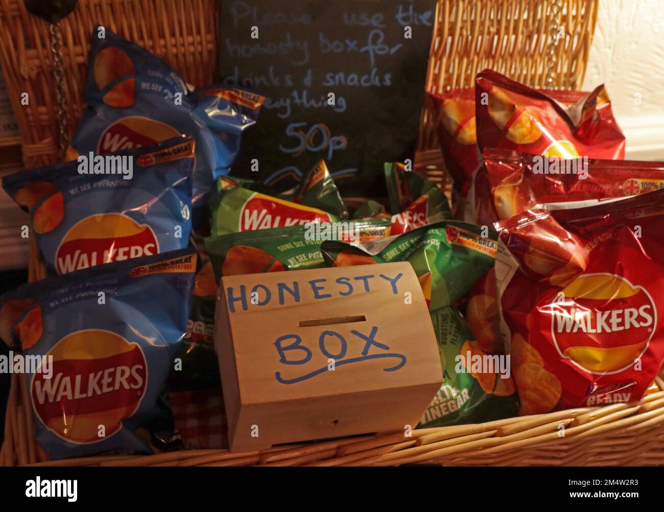 The office honesty box, surrounded by crisps and snacks - pay for what you eat Stock Photo