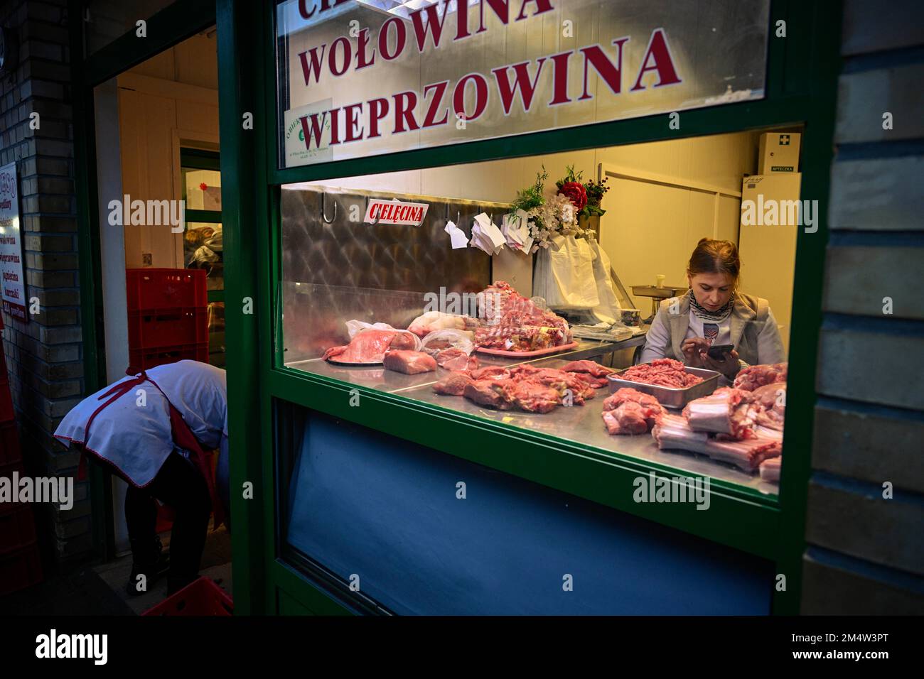A small butcher shop is seen with different types of meat on display at