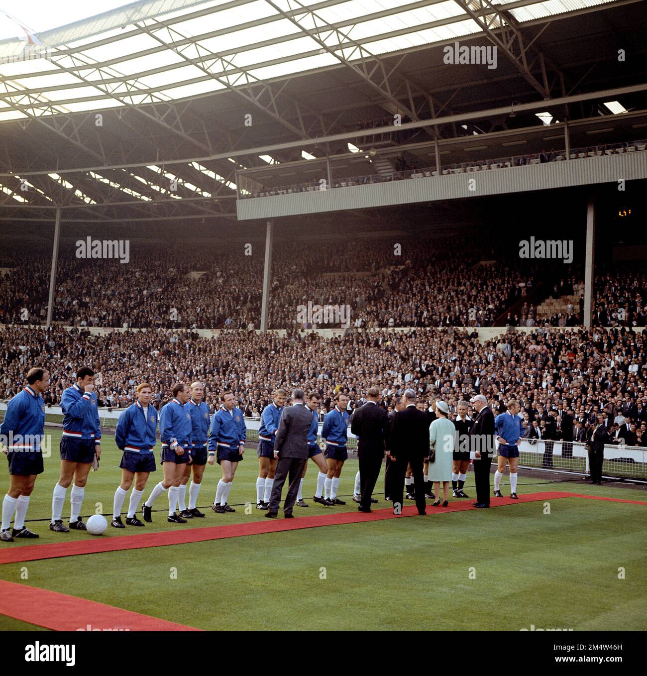 File photo dated 11-07-1966 of HRH Queen Elizabeth II (fourth r) is introduced to the England team by FIFA President Sir Stanley Rous (second r) before the opening match of the Finals. The England players are (l-r) George Cohen, Gordon Banks, Alan Ball, Ray Wilson, Bobby Charlton, Nobby Stiles, Roger Hunt, John Connelly, Jimmy Greaves, Jack Charlton (hidden), Bobby Moore (far r). Former England and Fulham defender George Cohen has died aged 83. Issue date: Friday December 23, 2022. Stock Photo