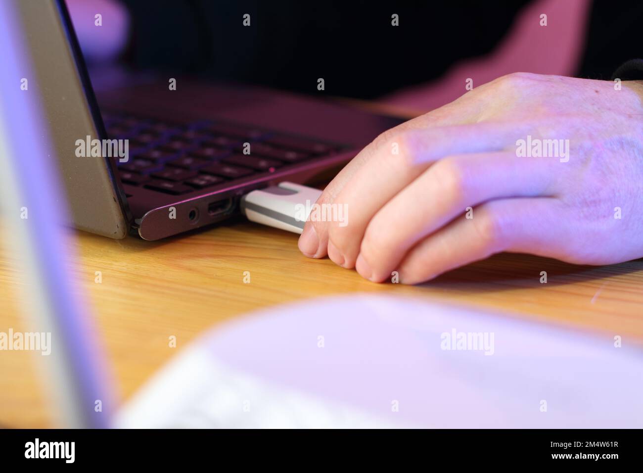 inserting a gsm modem into a laptop by a person in a black sweatshirt ...