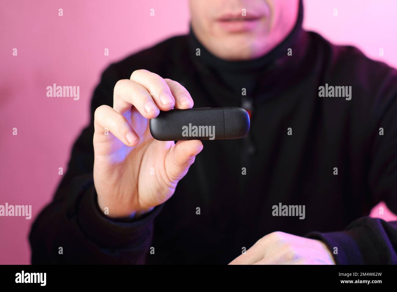 black gsm modem in the fingers of a hand against the background of a ...
