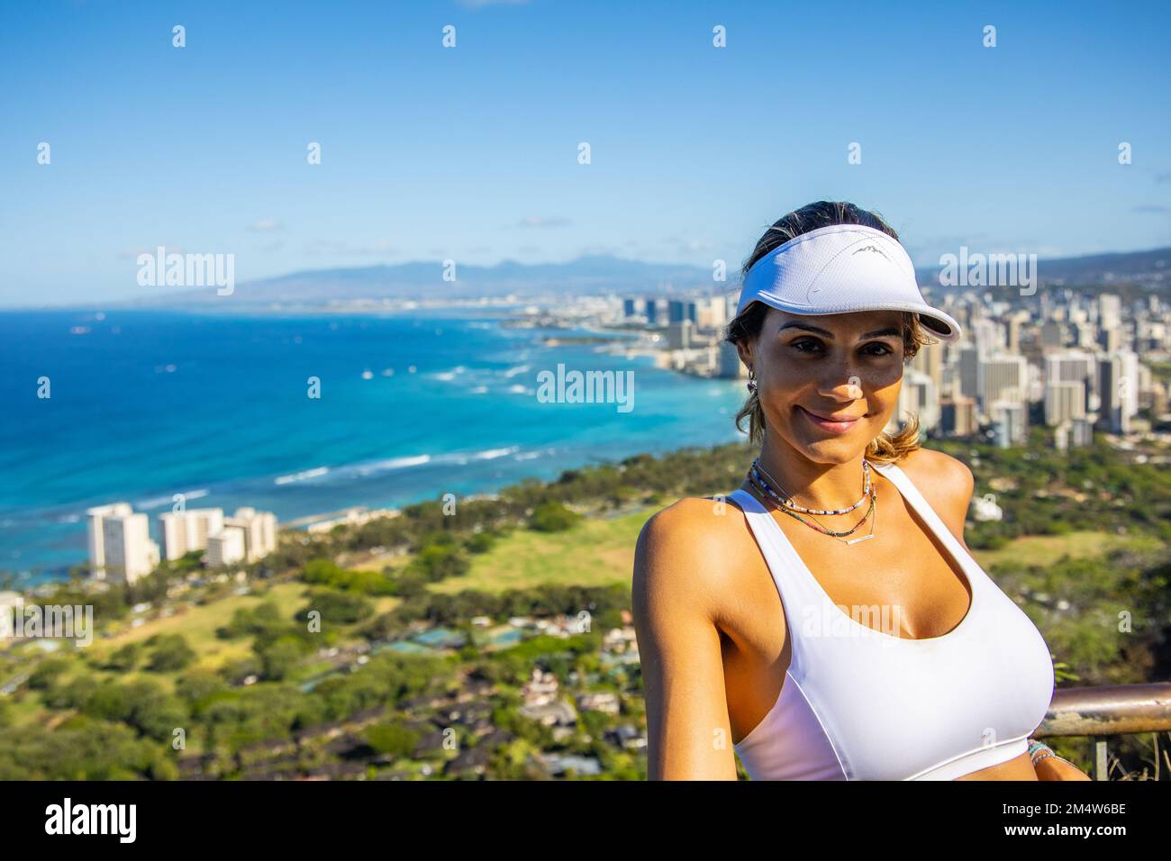 Portrait of a young Caucasian woman Enjoying hervacation on O'ahu Island, Hawaii with the city of Honolulu in the background Stock Photo