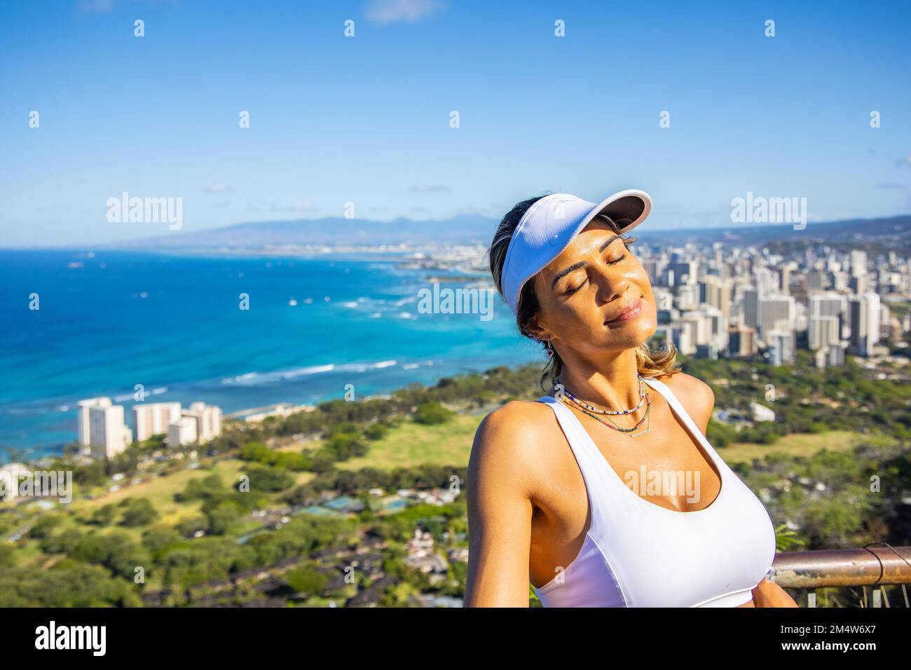 Portrait of a young Caucasian woman Enjoying hervacation on O'ahu Island, Hawaii with the city of Honolulu in the background Stock Photo