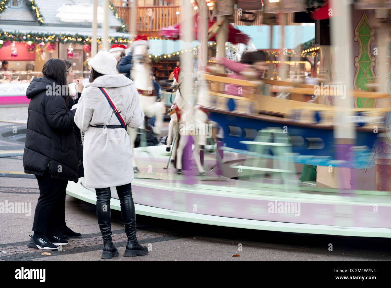 Eat, Deutschland. 22nd Dec, 2022. Passers-by stand in front of a carousel on the Weihaftertsmarkt on Kennedyplatz, pedestrian zone Essen, December 22nd, 2022 Credit: dpa/Alamy Live News Stock Photo