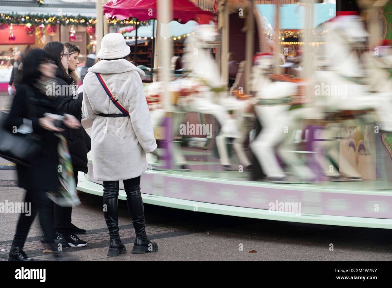 Eat, Deutschland. 22nd Dec, 2022. Passers-by stand in front of a carousel on the Weihaftertsmarkt on Kennedyplatz, pedestrian zone Essen, December 22nd, 2022 Credit: dpa/Alamy Live News Stock Photo