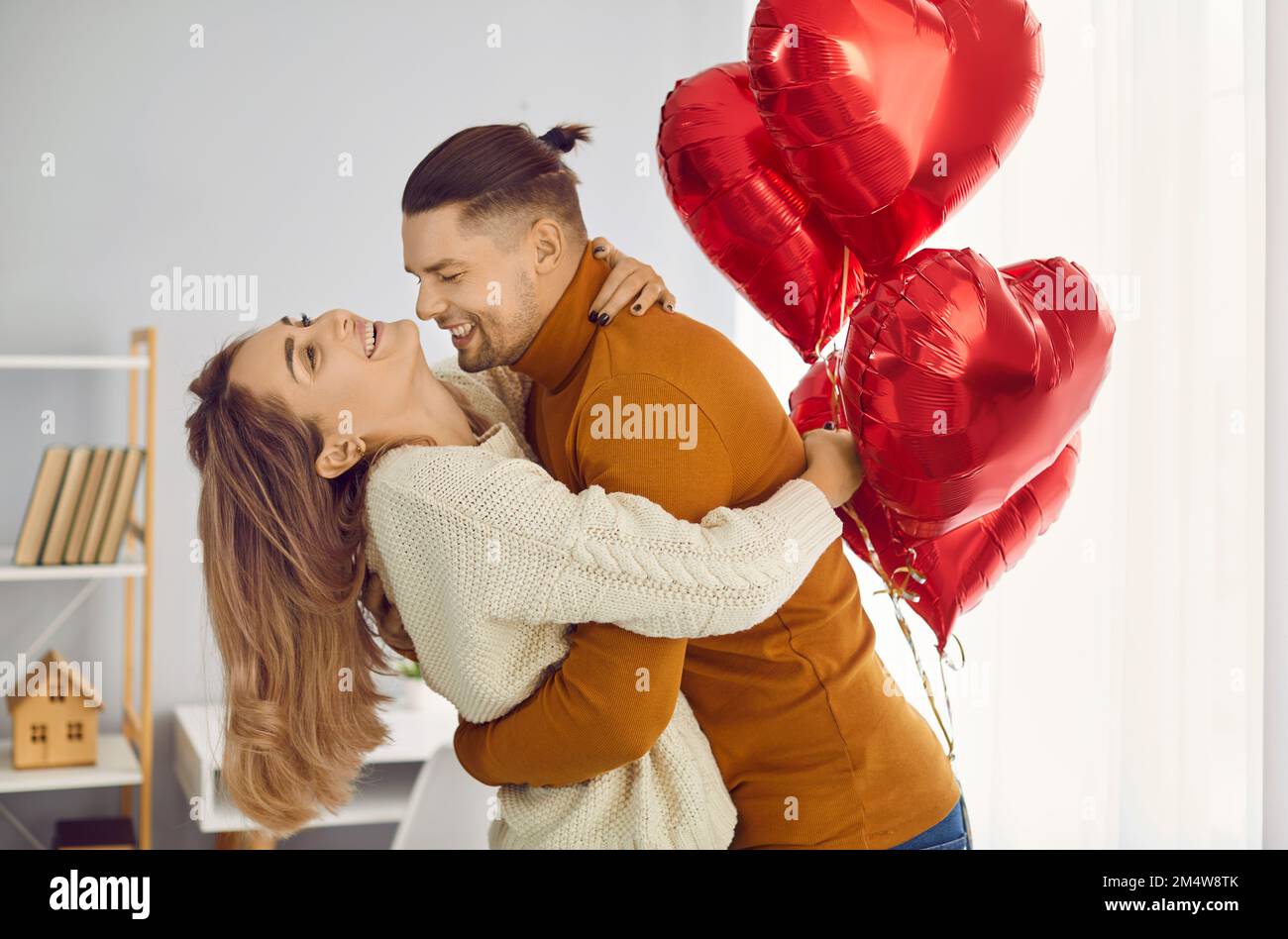 Happy young couple in love having fun while celebrating Saint Valentine's Day at home Stock Photo