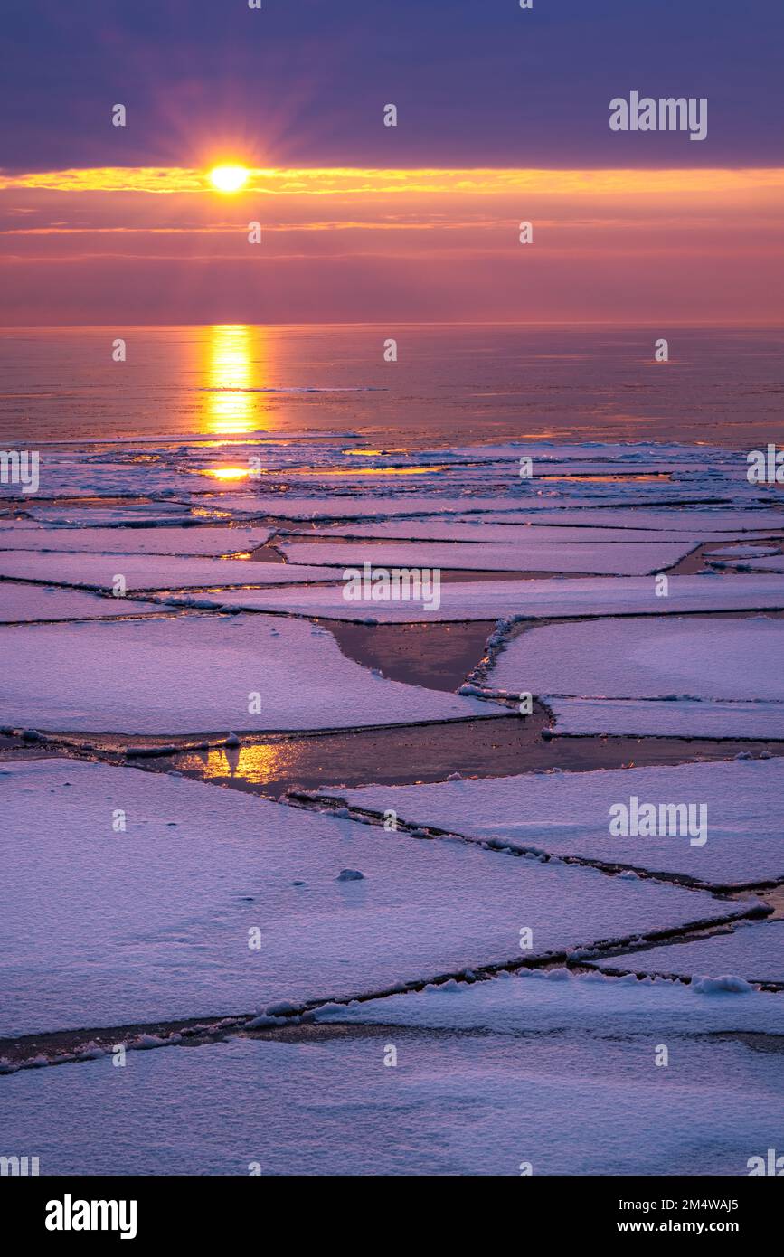 Ice floes on Lake Superior as the winter break up begins under a stunning sunrise over the greatest of the Great Lakes in Michigan's Upper Peninsula Stock Photo