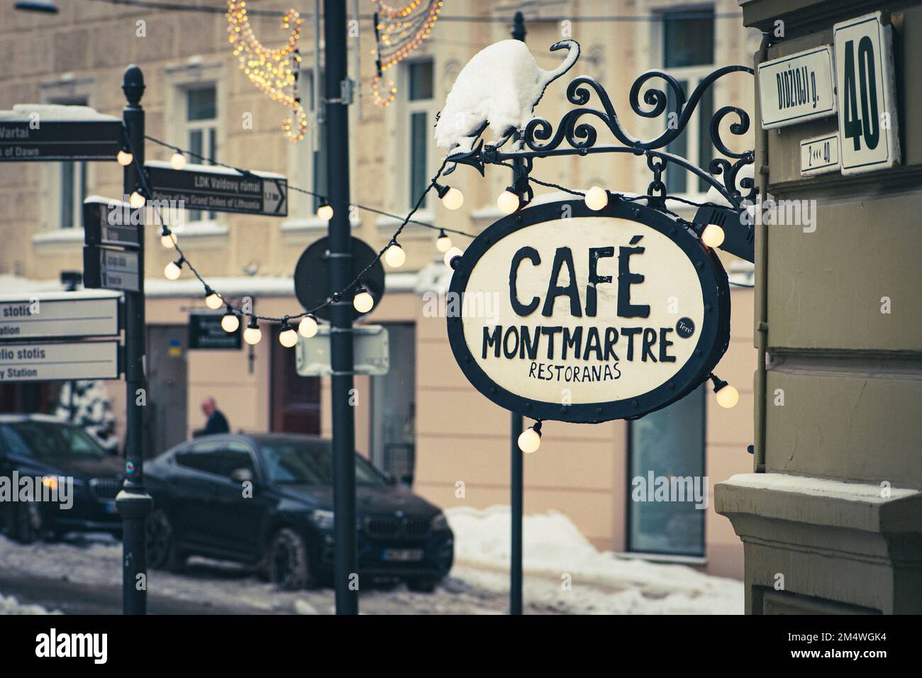 Cozy vintage Cafe Montmartre, restaurant or cafe in the old town of Vilnius, Lithuania in a cold winter day with snow, bulbs and lights in Vilnius Stock Photo