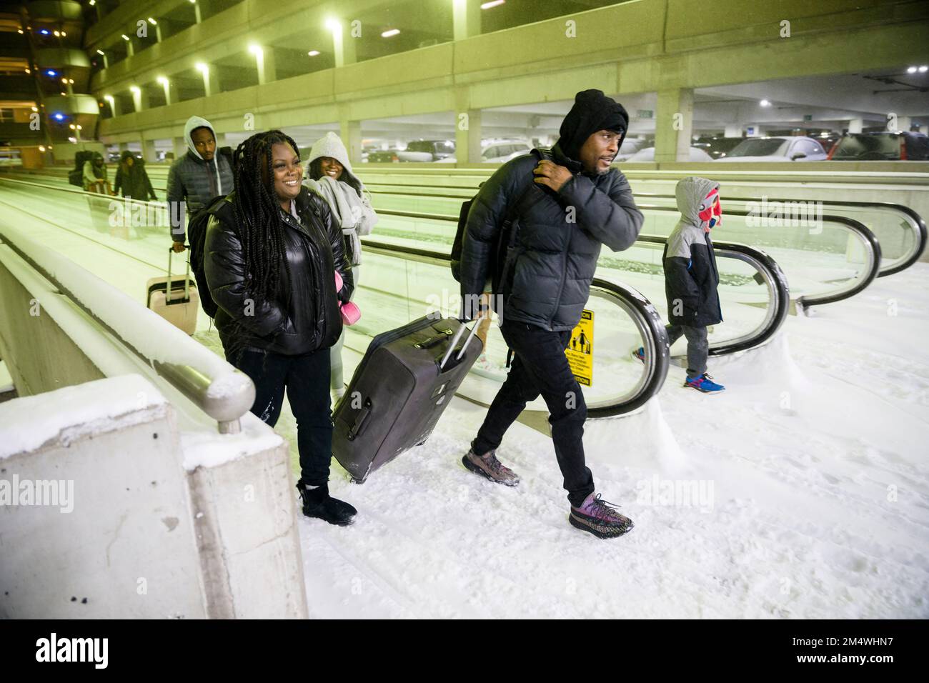 Columbus, Ohio, USA. 23rd Dec, 2022. Travelers talk along a snowed-over and frozen walkway in the parking garage of John Glenn Columbus International Airport in Columbus, Ohio as a major winter storm brings subzero temperatures across the United States. (Credit Image: © Jintak Han/ZUMA Press Wire) Stock Photo