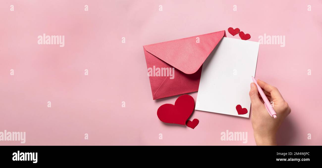 Valentines Day gift in the box, letter and envelope with copy space on pink background. Proposal of marriage, flat lay. Wedding invitation Stock Photo