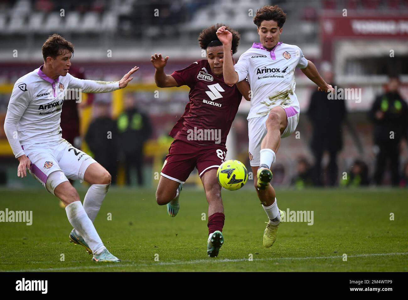 Turin, Italy. 23 December 2022. Aaron Ciammaglichella of Torino FC is challenged by Jack Hendry and Leonardo Sernicola of US Cremonese during the friendly football match between Torino FC and US Cremonese. Credit: Nicolò Campo/Alamy Live News Stock Photo
