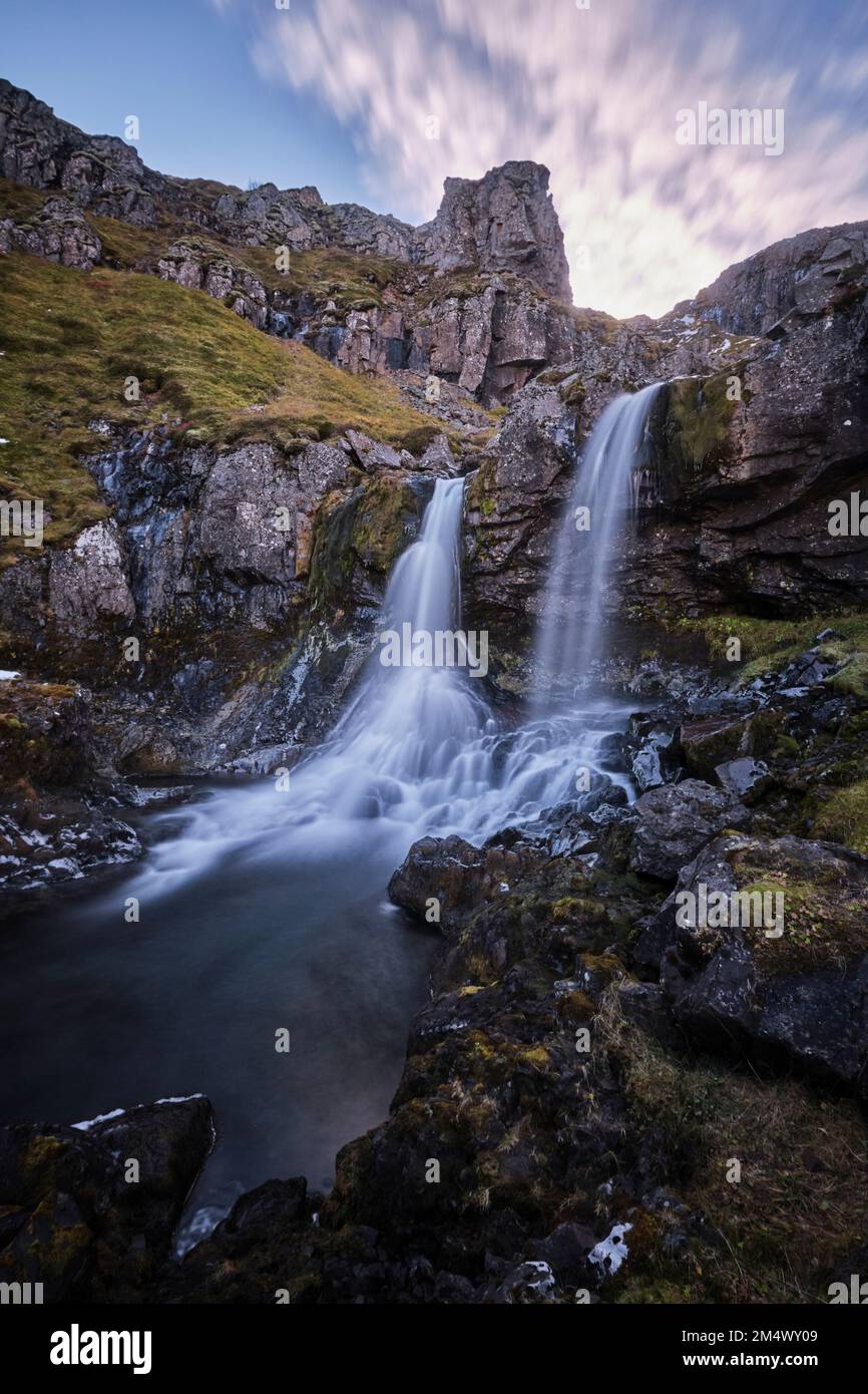 A vertical long exposure shot of the Klifbrekku Waterfall in Iceland ...