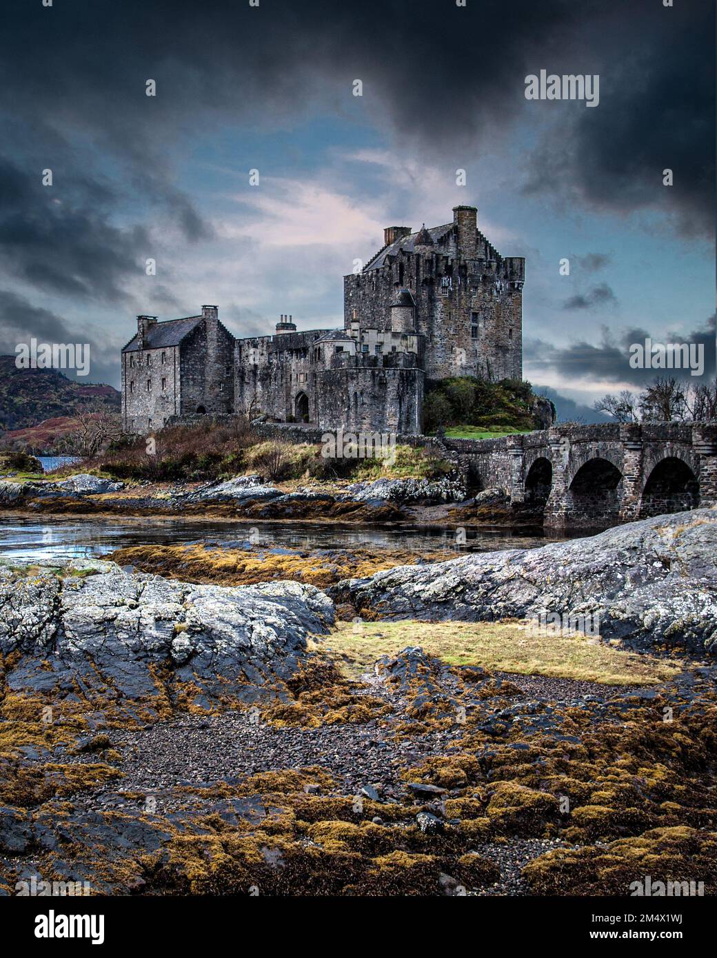 Eilean Donan Castle at the mouth of Loch Duich framed by heavy cloud Stock Photo