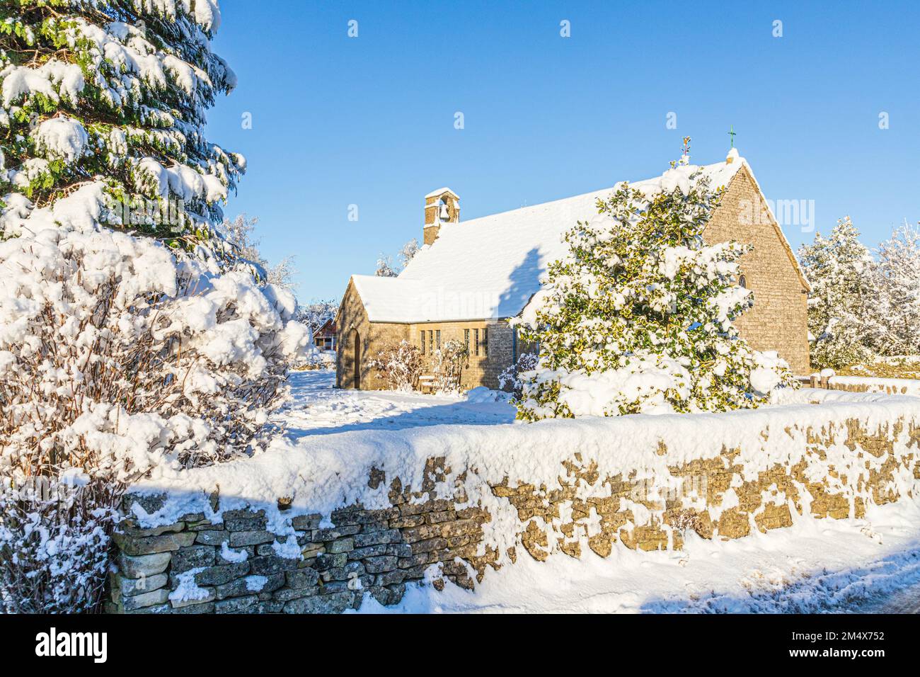 Early winter snow on the small stone church of St Mary in Hamlet (built 1958) in the Cotswold village of Birdlip, Gloucestershire, England UK Stock Photo