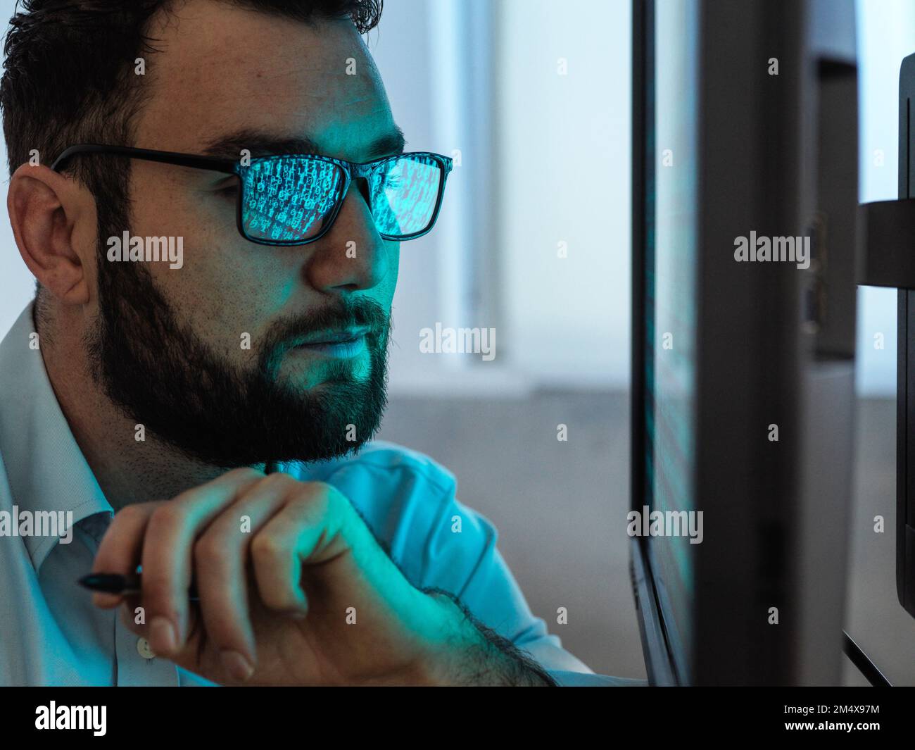 Programmer with beard hacking computer through virus Stock Photo