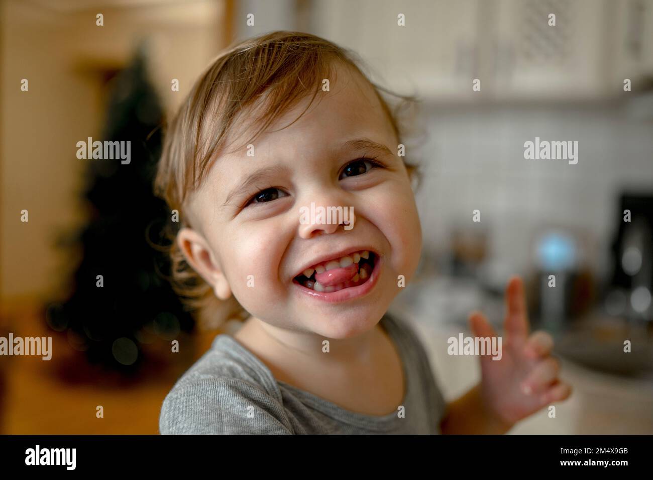 Cute little boy sticking out tongue at home Stock Photo Alamy
