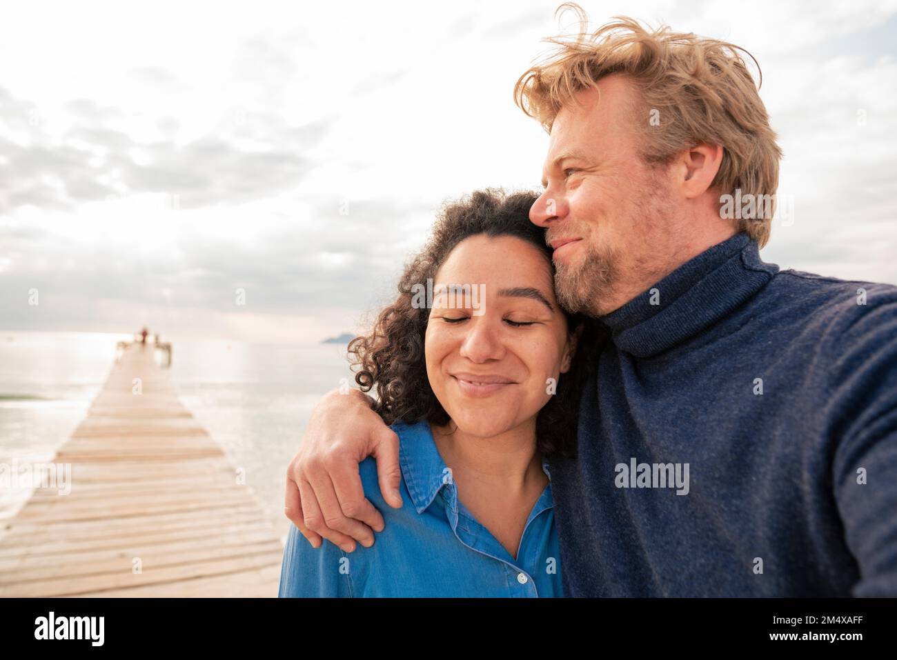 Couple on jetty by the sea hi-res stock photography and images - Alamy