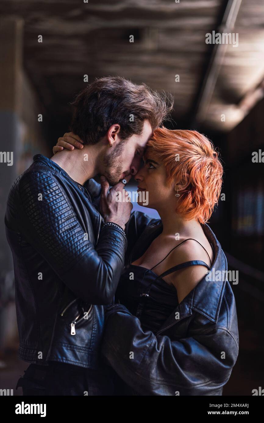 Affectionate young couple standing together in underpass Stock Photo