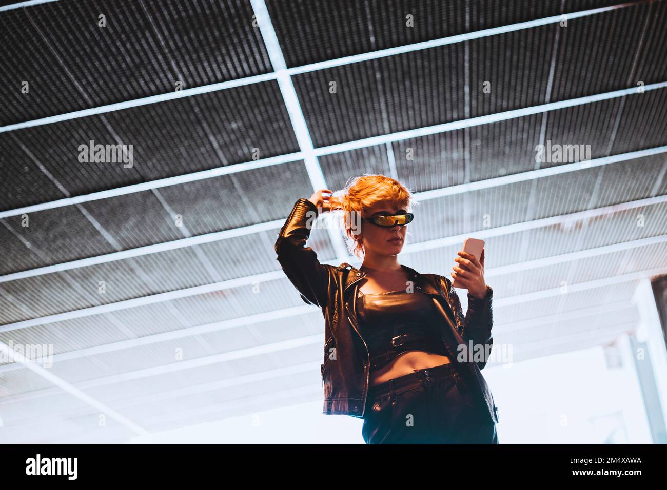Woman using mobile phone at underpass Stock Photo