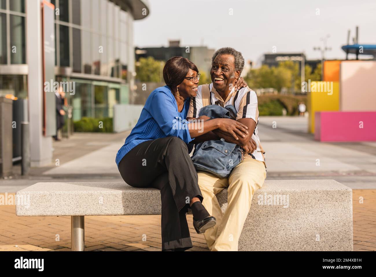 Happy senior couple sitting on bench Stock Photo