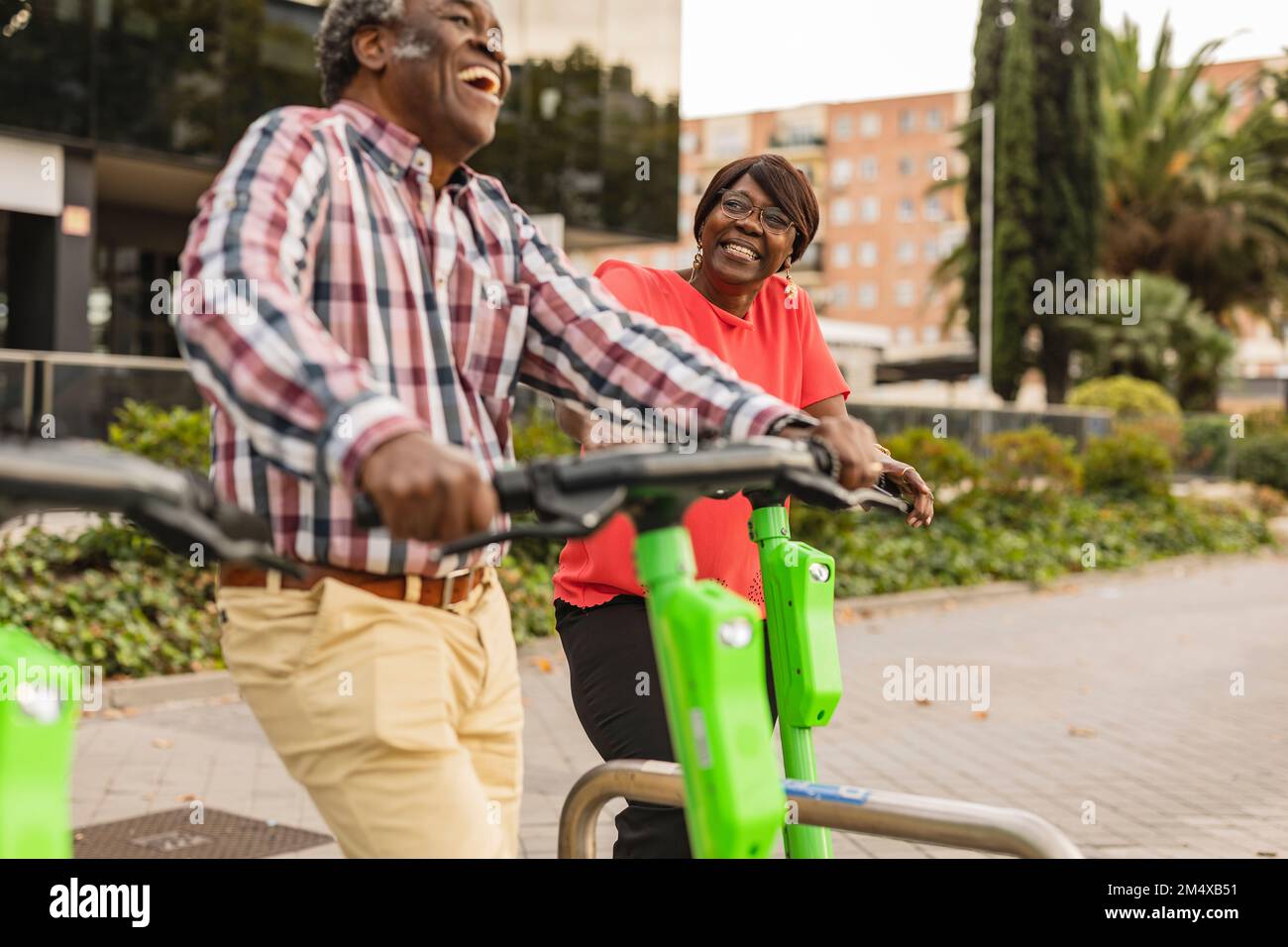 Happy senior couple spending leisure time with push scooters Stock Photo