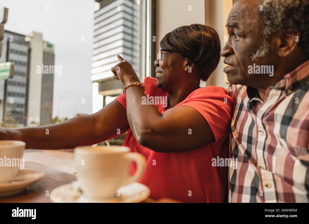 Smiling woman pointing by man at cafe Stock Photo