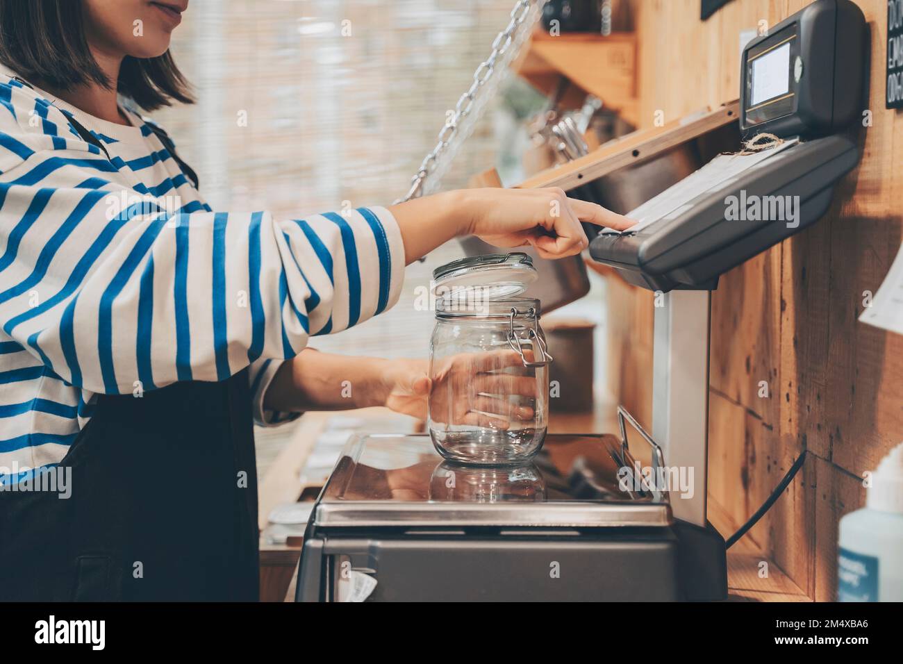 Customer weighing empty mason jar in zero waste store Stock Photo Alamy