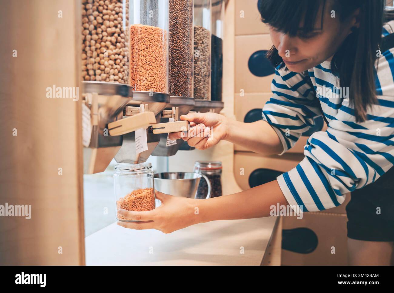 Customer filling jar with lentils in zero waste store Stock Photo Alamy