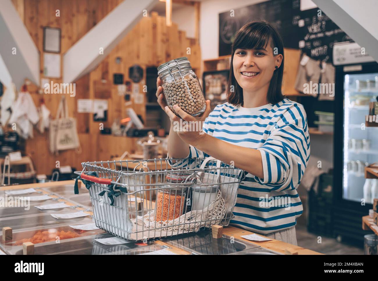Smiling customer showing chickpea jar in zero waste store Stock Photo