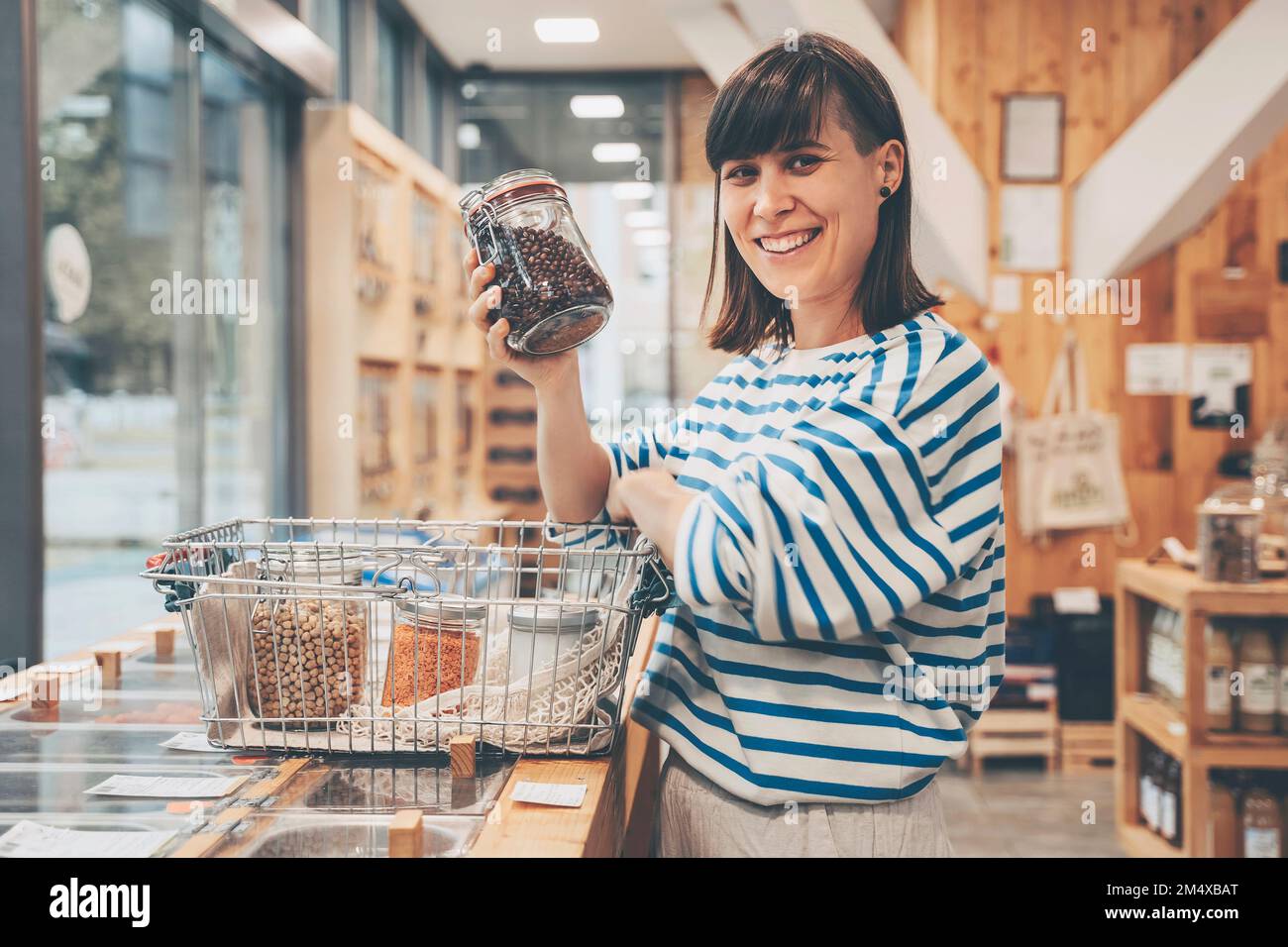 Smiling customer with kidney beans jar at counter in convenience store Stock Photo