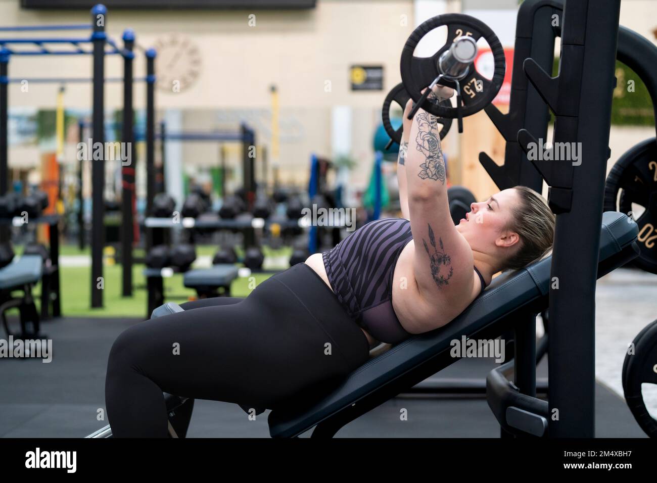 Chest press workout. Young woman exercising in gym Stock Photo - Alamy