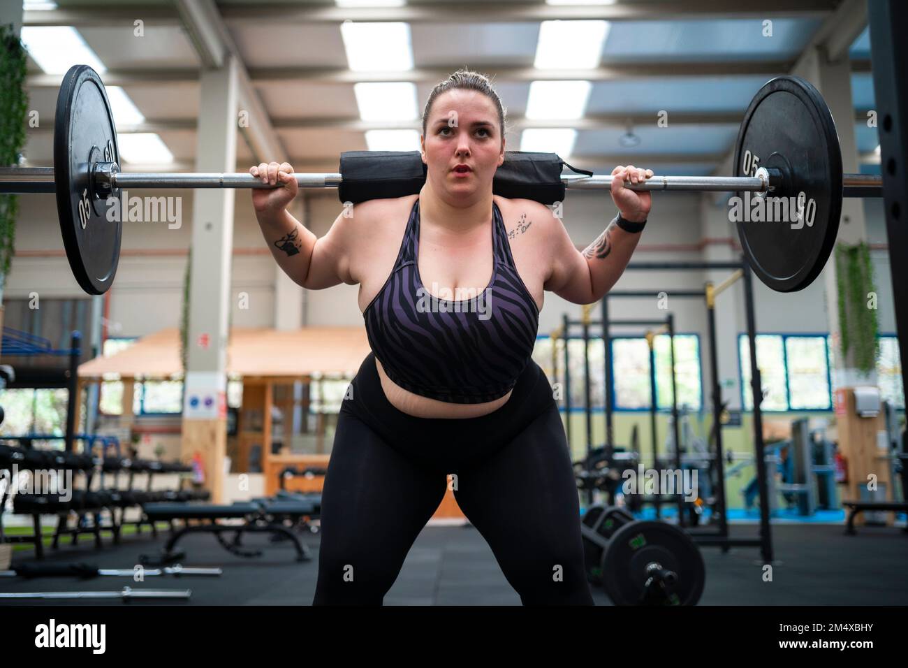 Personal Trainer Showing Young Woman How To Train Barbell Squats Exercise  In A Gym Stock Photo - Alamy
