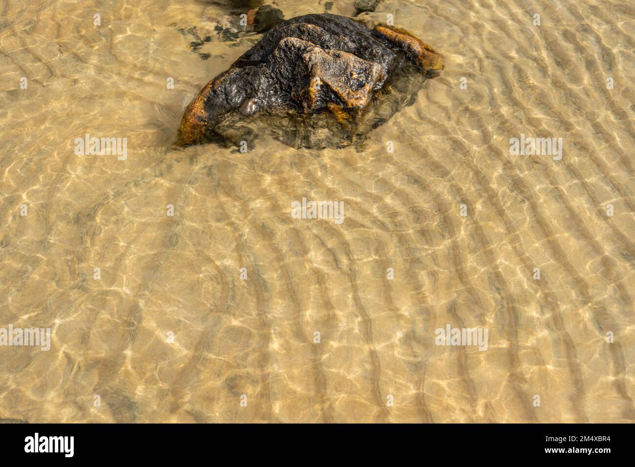 Shoreline rocks, sand ripples and shallow water, Lake Superior ...