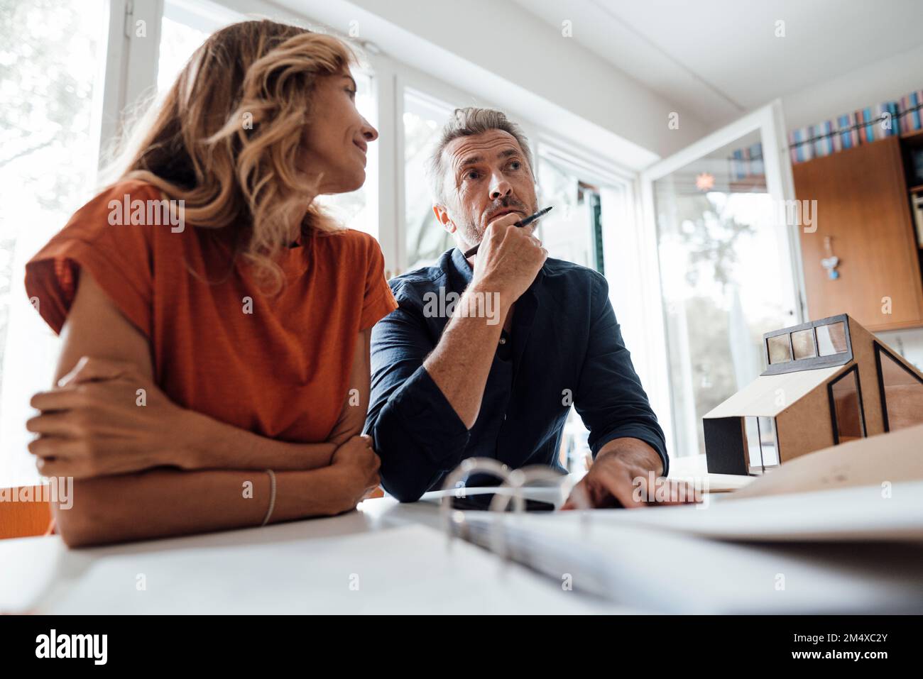 Mature man and woman discussing over real estate contract at table Stock Photo