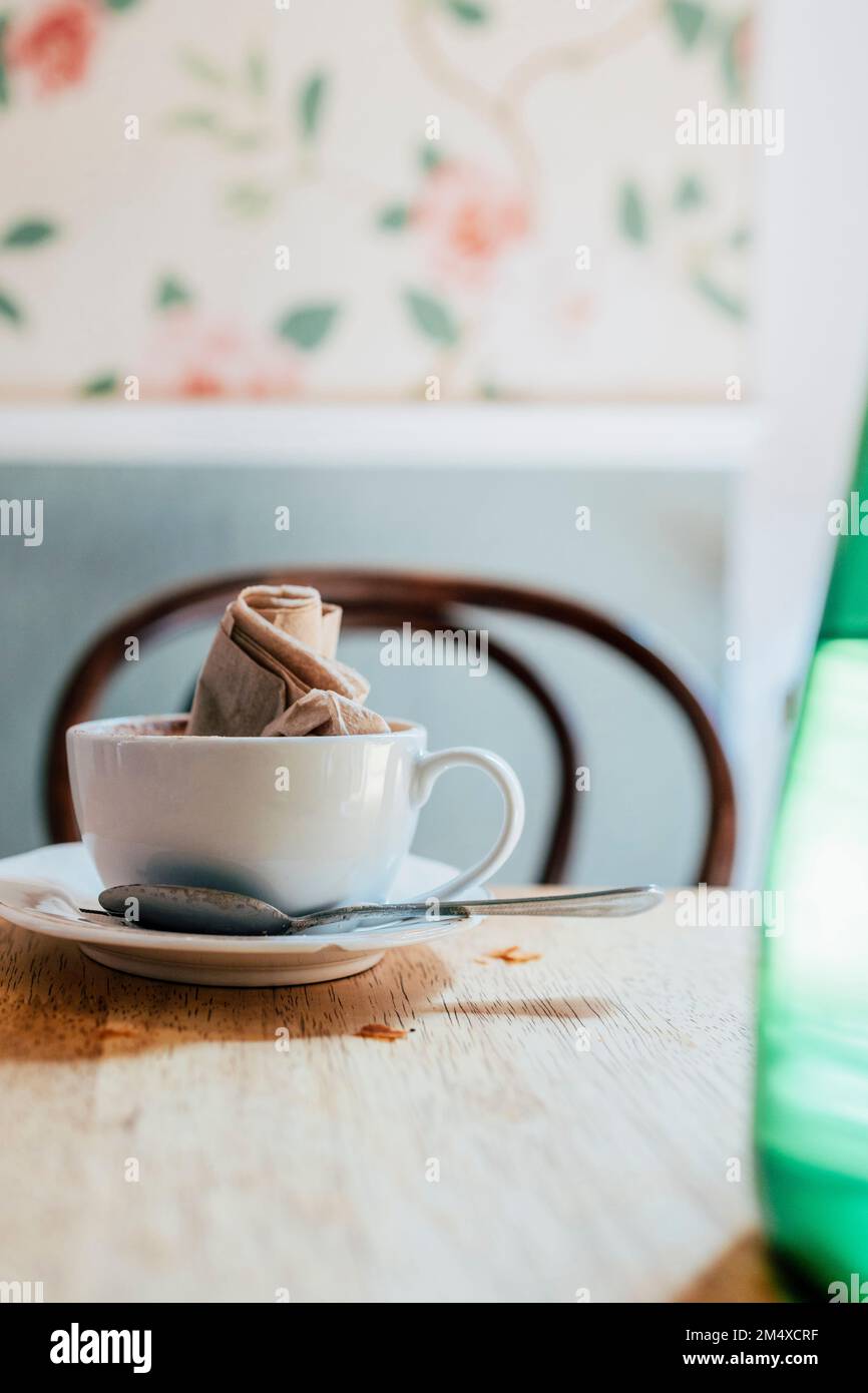 Empty coffee cup with crumpled napkin on table Stock Photo