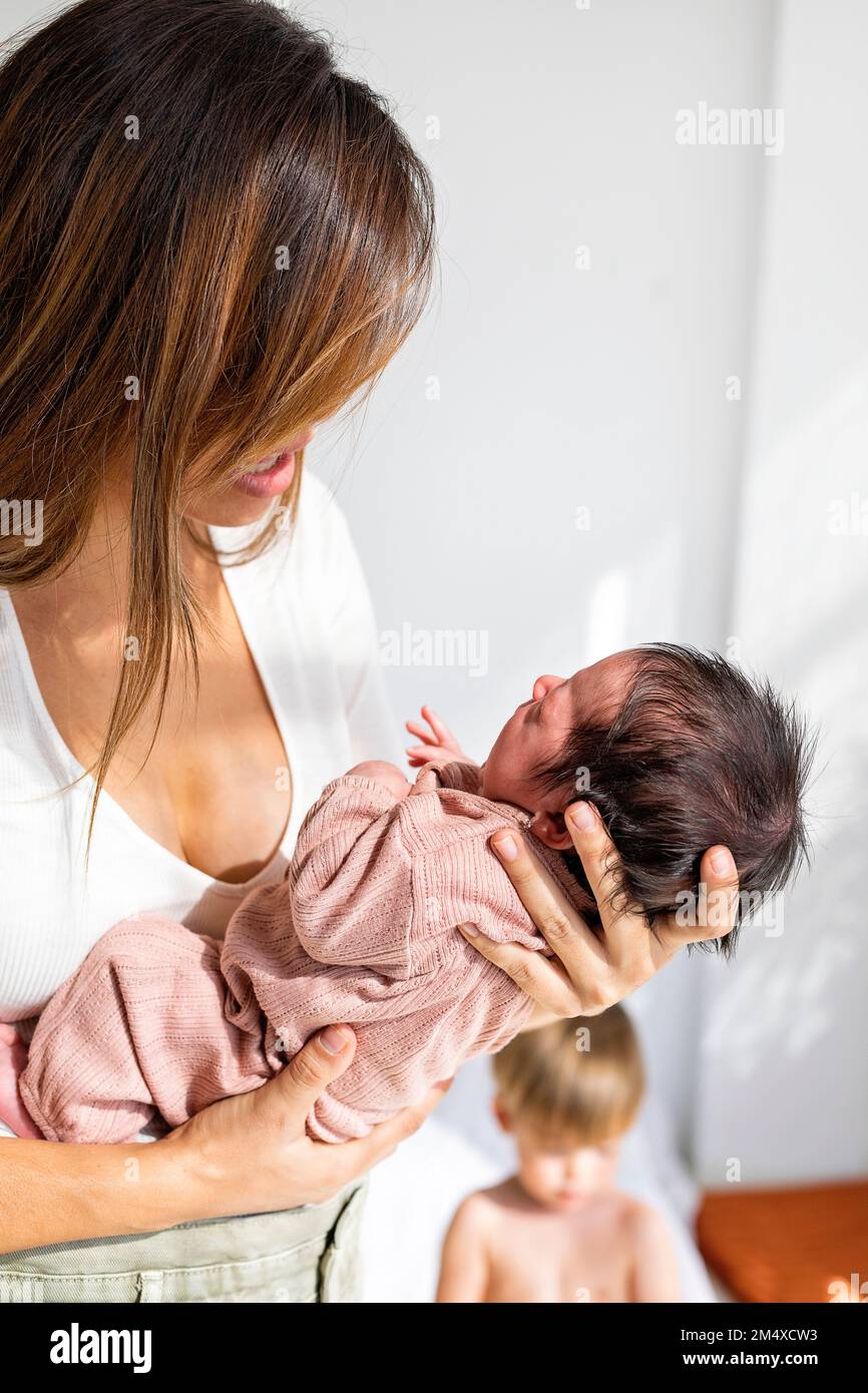 Mother holding newborn daughter at home Stock Photo Alamy