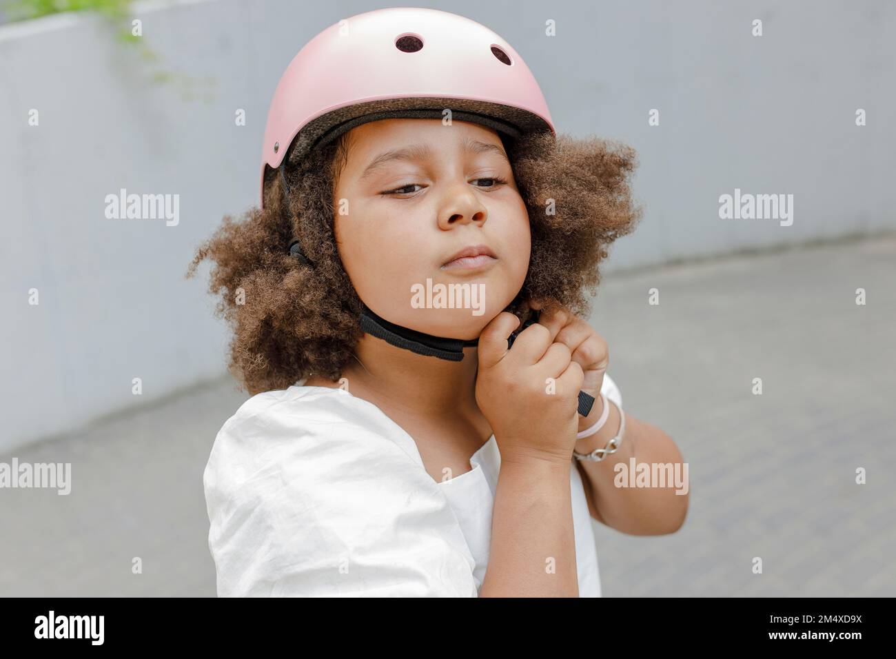 Girl with Afro hairstyle adjusting sports helmet Stock Photo Alamy