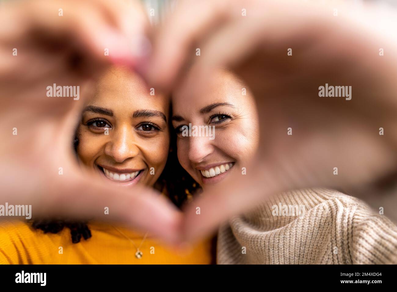 Happy women making heart shape gesture Stock Photo